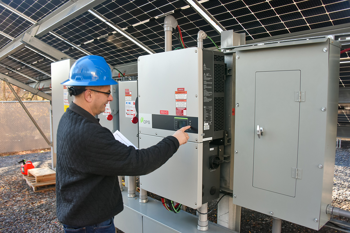 BC Energy employee examining solar panel equipment