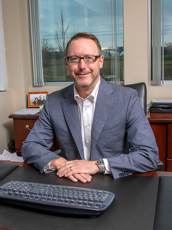 John Moynihan-Headshot John Moynihan, Vice President of BC Energy, smiling and seated at his desk.